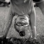 Girl doing a headstand in the grass