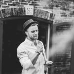 groomsmen singing at a wedding in black and white